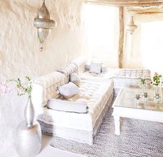 a living room filled with furniture and flowers in vases on top of the tables