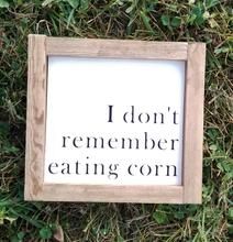 a sign that says i don't remember eating corn on the ground in grass