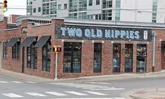 two old hippies restaurant on the corner of an intersection in front of tall buildings