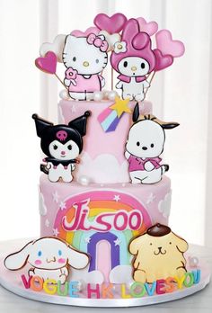 a hello kitty birthday cake with lots of cats and dogs on the top, all decorated in pink