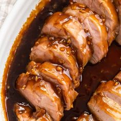 sliced pork with sauce in a white bowl