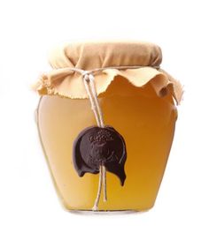 a jar filled with honey sitting on top of a table