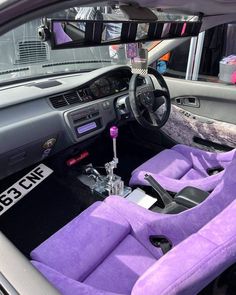 the interior of a car with purple cloth seats and steering wheel, in front of a mirror