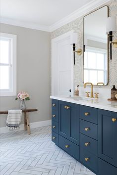 a bathroom with blue cabinets and gold handles