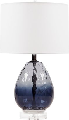 a blue glass table lamp with a white shade on the top and bottom part of it