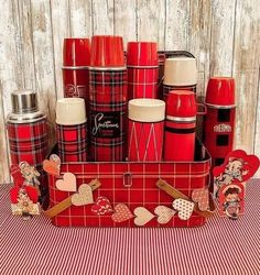 red and white plaid table cloth with tins, cups and magnets on it