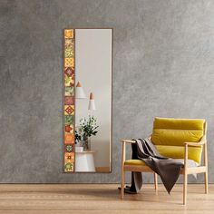 a yellow chair sitting in front of a mirror on a wall next to a potted plant