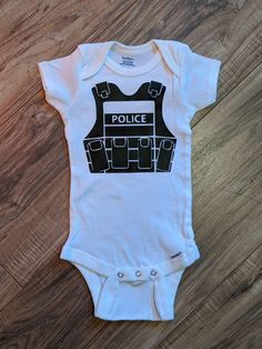 CUSTOM BABY BODYSUIT- Perfect gift for baby showers! - Heat transfer vinyl. [Heat pressed] Shirts will come in the color shown unless you private message and specify that you would like a different color (upon availability.)  Add a name on the back for an additional $2. Shirts are 100% Pre-shrunk cotton. Please wash inside out! ALL SALES FINAL. I will always send a picture of the process and finished product for you to approve before sending. If there is any issues with the quality of your order once you receive it, please private message me within one week so I can try my best to fix anything for you. Police Tactical Vest, Police Tactical, Heat Press Shirts, Anything For You, Tactical Vest, Gender Neutral Baby Clothes, Custom Baby, Transfer Vinyl, Gender Neutral Baby