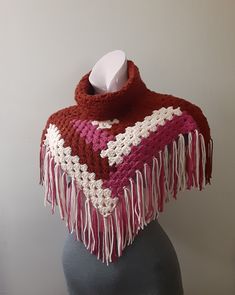 a red and white crocheted shawl on a mannequin's head