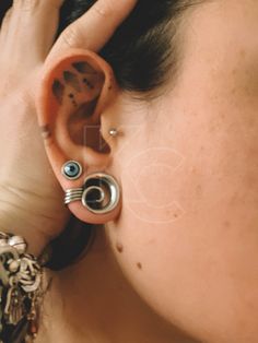 a close up of a person with ear piercings on their ears and behind the ear