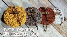 three crochet star stitch coin drawstring pouches on a wooden surface