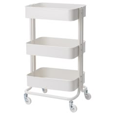 a three tiered shelf with wheels and two baskets on each side, in white