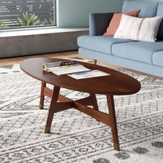 a living room with a blue couch and coffee table in the middle of the room