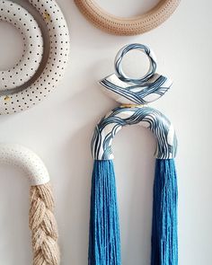 two decorative objects are hanging on the wall next to each other with tassels