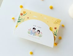 a card with two people on it sitting next to some yellow and white candies