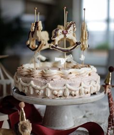 a cake with white frosting and brown icing decorated with miniature horses on top