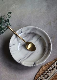 a marble bowl with a gold spoon in it