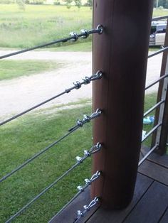 a close up of a metal pole on a wooden deck with grass in the background