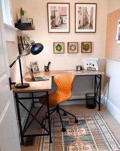 an orange chair sits in front of a desk with pictures on the wall behind it