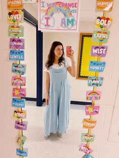 a woman taking a selfie in front of a mirror with colorful signs on it