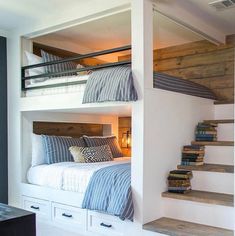 bunk beds are built into the side of each other in this small room with stairs leading up to them