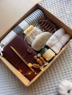 an open box with various items in it on a white surface next to pumpkins