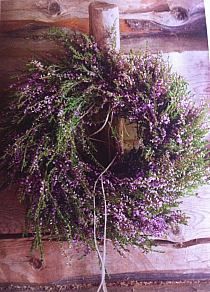 a wreath with purple flowers hanging from it