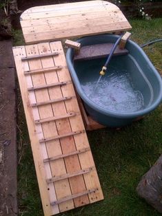 a bathtub is being built and placed next to a wooden platform with a plunger in it