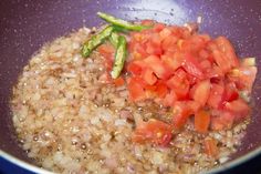 tomatoes and asparagus are being cooked in a pan