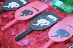 some pink and black paddles are laying on red tissue