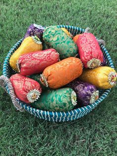 a basket filled with colorfully decorated eggs on top of green grass in the grass