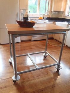 a kitchen island with wheels on it in the middle of a wooden flooring area