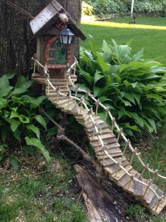 a tree house with a rope bridge going up it's side in the grass