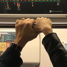 two hands are holding onto each other on a train