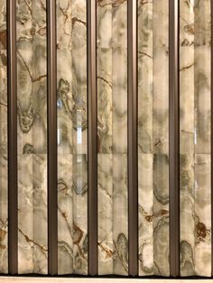 the marble wall is lined with brown and white stripes on it's sides, as well as metal bars