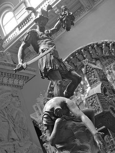 black and white photograph of a statue in the middle of a building