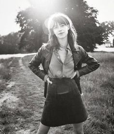 a woman standing in the middle of a field with her hands on her hips