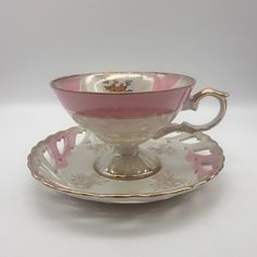 a pink and white tea cup on a saucer