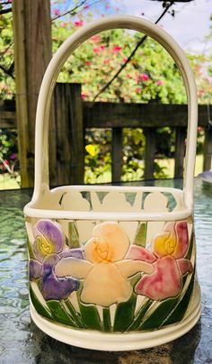 a white basket with flowers painted on it