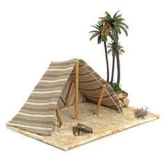 a model of a tent with palm trees and other items on the ground next to it