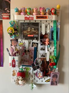 a wall mounted shelf filled with lots of toys and magnets on top of it