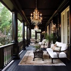 an elegant porch with chandelier and white couches on the wooden flooring