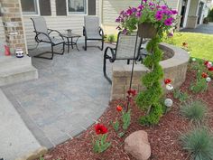 an outdoor patio with flowers and chairs