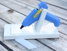 a blue and white stapler sitting on top of a piece of wooden planks