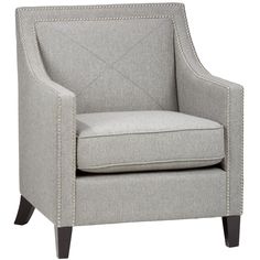 a light gray chair with studding on the armrests and back rests against a white background