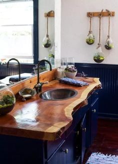 a wooden counter top sitting under a window next to a sink and faucet