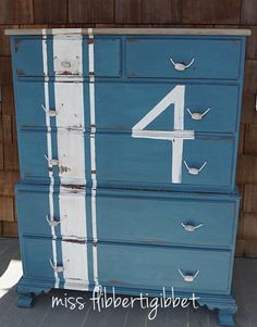 a blue dresser with white numbers painted on it