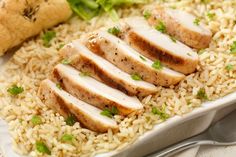 a white plate topped with rice and sliced chicken