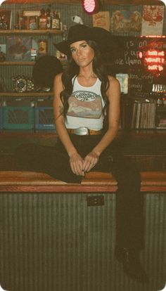 a woman sitting on top of a wooden counter