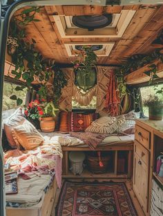 the inside of an rv with plants and pillows on it's bed, as seen from the rear door